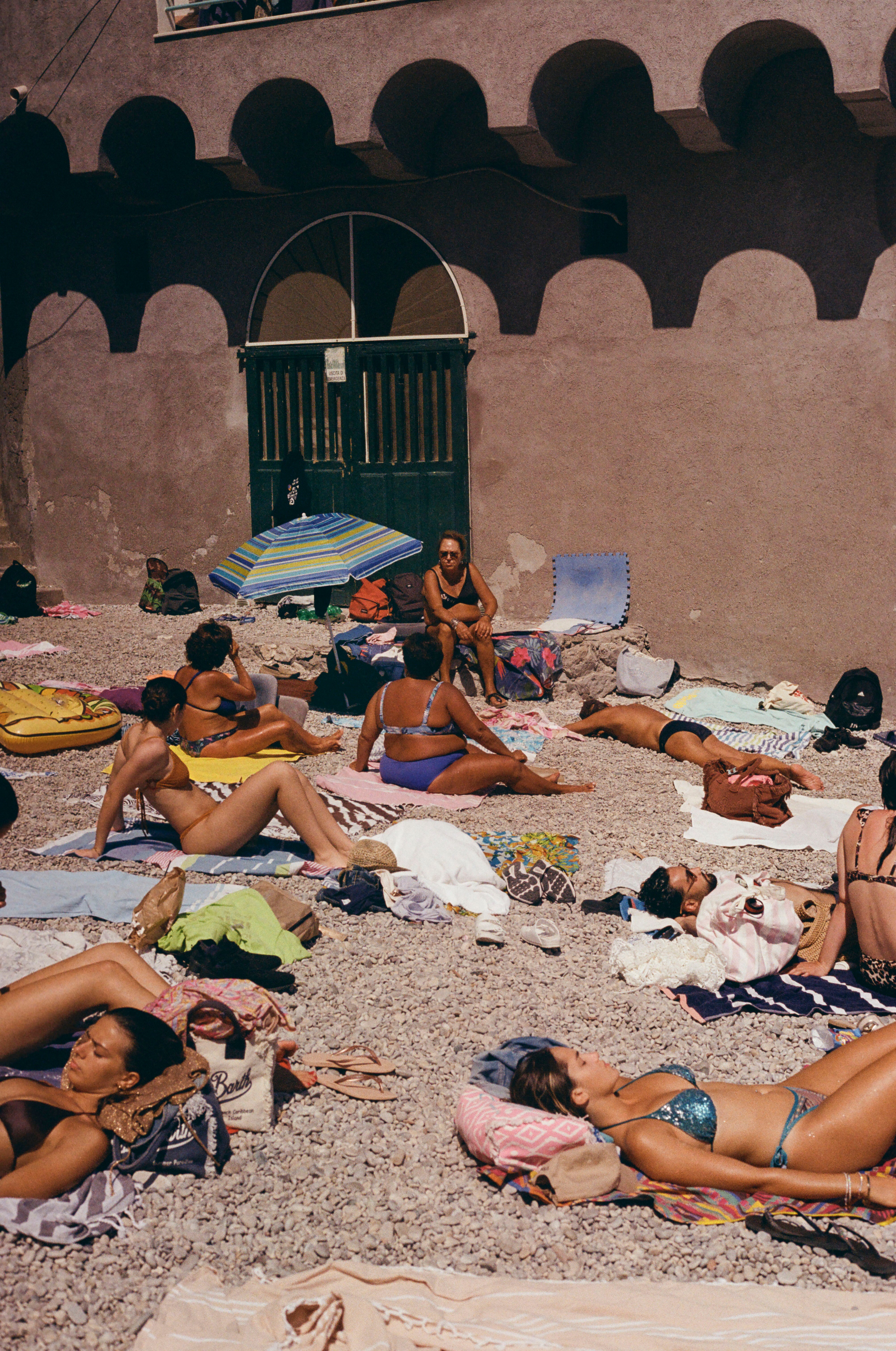 Photograph of sunbathers enjoying the shoreline at Marina Piccola in Capri, Italy.